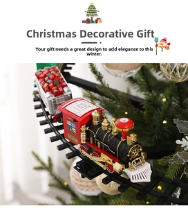 Close-up of electric Christmas train toy with engine and gift car on a tree track