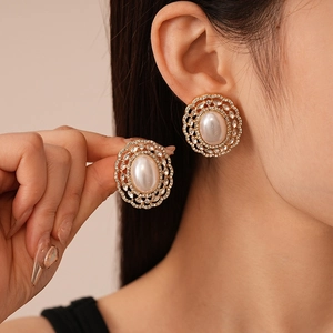 Vintage gold oval pearl earrings with sparkling crystal accents worn by a model