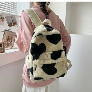 Detailed view of plush heart-patterned backpack with soft faux fur and beige straps
