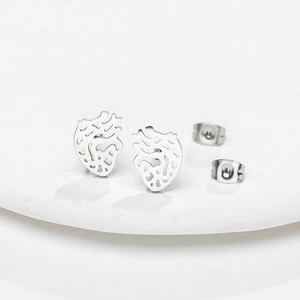 Close-up of silver anatomical heart stud earrings with detailed hollow-out design