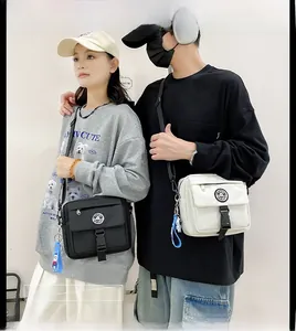 Detail of couple matching technical crossbody bags with buckle pocket and cartoon charm