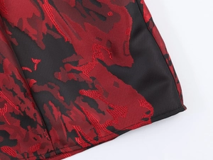 Gros plan sur le tissu jacquard vintage aux motifs rouge foncé et finitions de couture