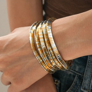 Detail shot of multi-layer geometric metal bracelet in gold and silver mixed tones