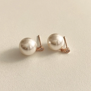 Macro view of 925 silver pearl stud earrings with zircon inlay and rose gold finish