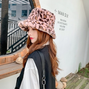 Outdoor side view of a women's pink leopard print plush bucket hat in faux rabbit fur
