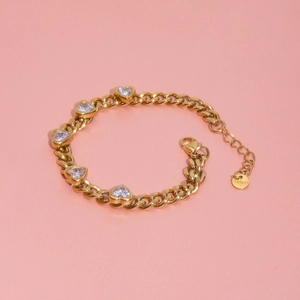 Detail of gold-plated stainless steel bracelet featuring five white heart-shaped zircons