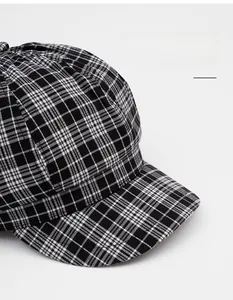 Close-up of black and white plaid octagonal hat with wide brim and woven texture