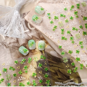 Detailed view of four-leaf clover nail stickers with Japanese lettering and gold accents