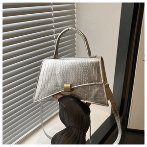 Detail of silver crocodile pattern handbag with elegant golden rectangular metal lock