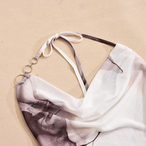Detail of mesh dress neckline with metallic ring and black-and-white ink print pattern