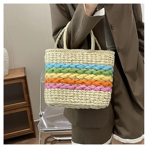 Close-up of a striped woven straw tote bag with colorful handles and bohemian beach style