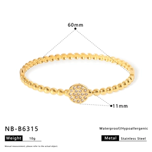 Gold stainless steel beaded bracelet with zircon rotating disk on white background
