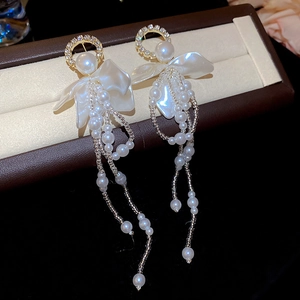Close-up of elegant floral tassel earrings with pearls and crystals on a jewelry tray