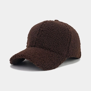 Detailed close-up of dark brown lamb wool fabric texture on a warm winter baseball cap