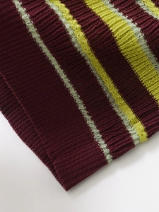 Close-up of burgundy and green striped knit top showing ribbed texture and fine stitching