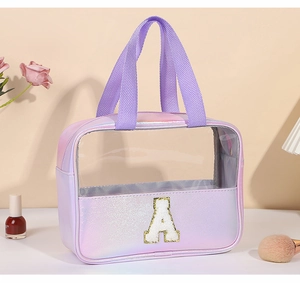 Dettaglio trousse olografica viola con toppa dorata a forma di A e finestra trasparente in PVC