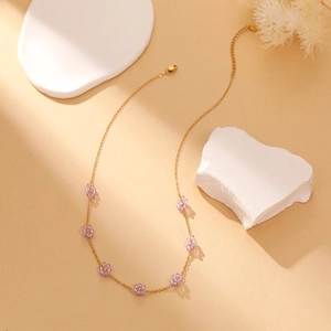 Detail of gold fine chain necklace featuring seven lavender crystal flower charms