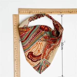 Flat lay detail of paisley print headscarf with size labels 25cm by 30cm and elastic band