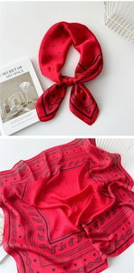 Macro detail of red paisley silk scarf with black floral print and smooth rolled edges