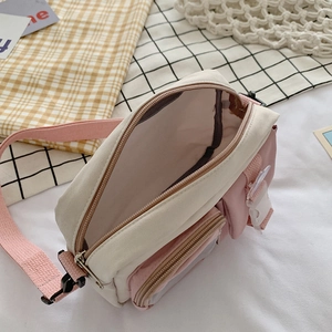 Pink and beige canvas crossbody bag with multi-pocket design and adjustable shoulder strap