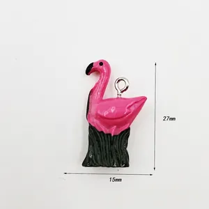 Pink flamingo resin pendant with green grass base and size markings 27mm by 15mm