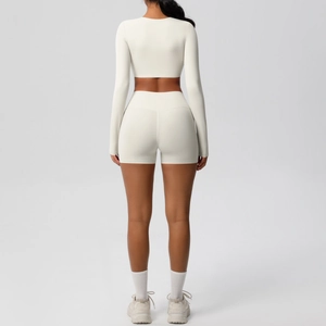 Back view of cream white yoga set featuring long sleeve crop top and high waist sports shorts