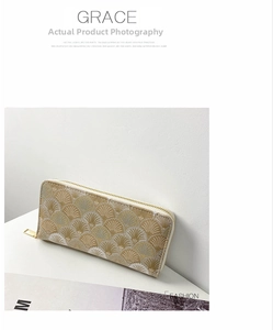 Detail of elegant long zipper wallet showing golden shell embroidery and metal hardware