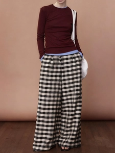 Detailed view of high-waisted black and white plaid wide-leg trousers on a model