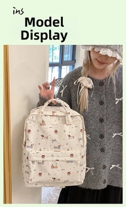 Detail of white graffiti backpack with cartoon dachshund print and bow tie accents