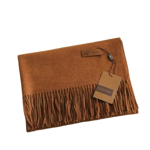 Solid caramel cashmere-feel scarf with tassels and leather brand label on white background