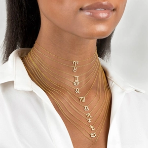 Layered gold zodiac necklace set with zircon stones on model showing full collection