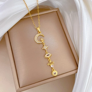 Close-up of gold star and moon pendant necklace with pavé zircon stones on satin