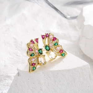 Gold-plated butterfly stud earrings with colorful cubic zirconia on a white stone base
