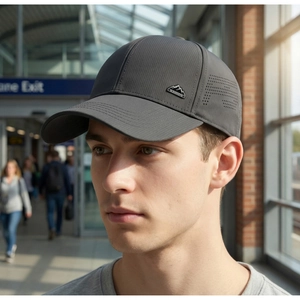 Detail of grey mesh baseball cap featuring breathable laser perforations and mountain logo