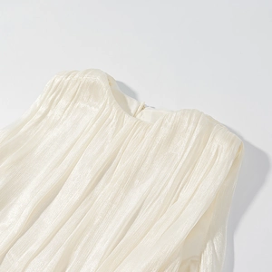 Detail of a champagne sleeveless top with pleated texture and a round neckline