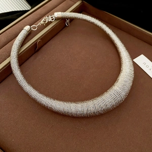 Detailed silver spiral coil choker necklace with lobster clasp on jewelry tray