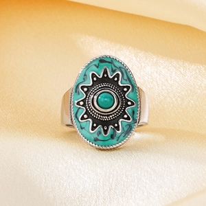Macro shot of oval vintage ring with turquoise bead and sunburst detail on silk