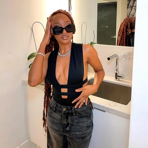 Détail d'un body ajouré à col en V plongeant porté avec un jean délavé et des accessoires