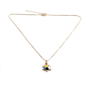 Macro shot of gold-plated turtle pendant with vibrant multicolor enamel mosaic details