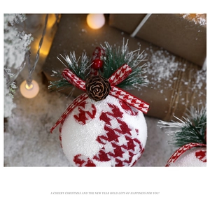 Detail of a Christmas ball with red houndstooth fabric, pine cones and a red bow