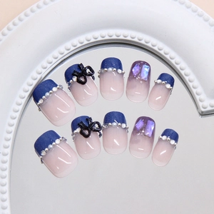 Glacier blue French press-on nails with 3D black bows and silver pearl rhinestones