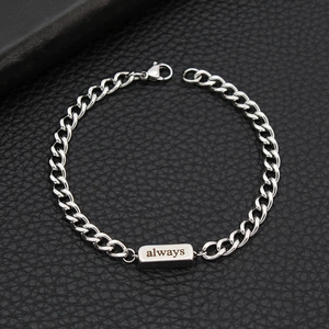 Macro view of silver stainless steel chain bracelet with an engraved rectangular always tag