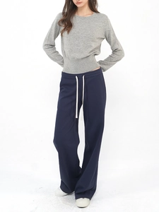 Detail of grey wool knit sweater with button design and navy drawstring trousers
