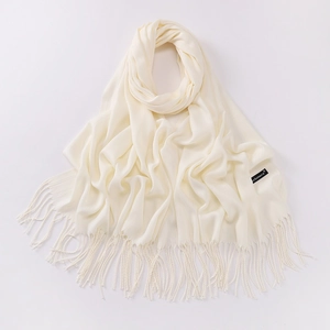 Detail view of cream white scarf with fringe, soft cashmere texture and side label