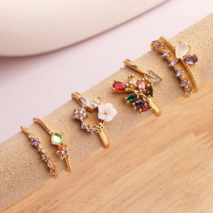 Macro detail of 4-piece 18K gold-plated floral rings set with colorful zircons