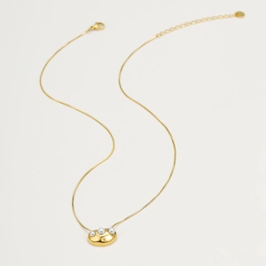 Minimalist gold snake chain necklace with three pearl pendants on a white background