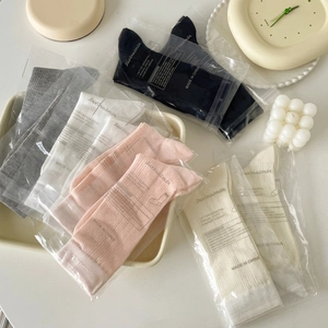 Classic cotton knit crew socks in neutral solid colors with individual retail packaging