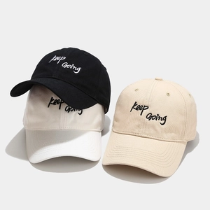 Three baseball caps in black, beige, and khaki with Keep Going embroidery detail