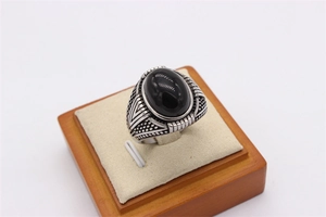 Détail d'une pierre noire ovale sertie dans une bague en acier inoxydable rétro