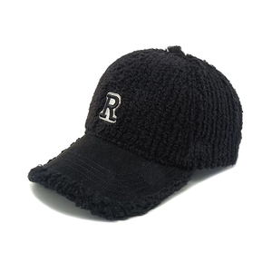 Vue détaillée du tissu polaire sherpa noir moelleux et de la broderie de la lettre R